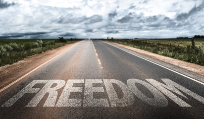 Naklejka premium Freedom written on rural road