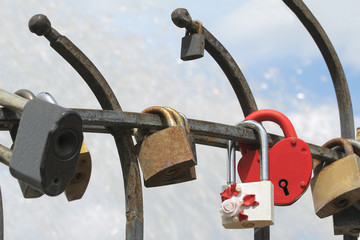 Bride and groom hang a padlock on the bridge as a sign of love