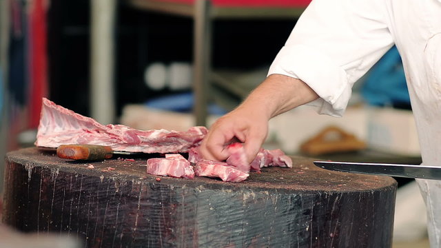 Close-up butcher cuts meat on skewers