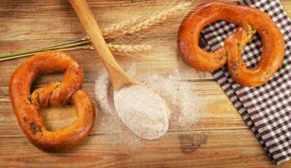 Two Freshly baked pretzels on a wooden table.