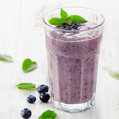 Glass of blueberry smoothie with mint.