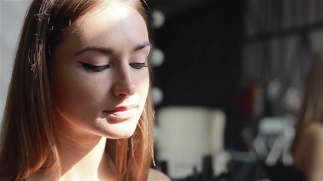 Professional make-up artist applying light eye shadow. Close-up