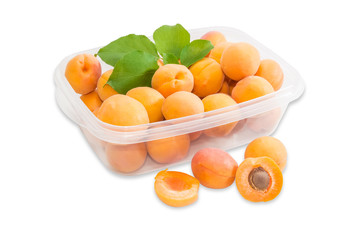 Ripe apricots in plastic tray and several apricots separately cl