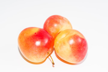three orange ripe plums isolated on a white background