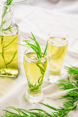 Bright summer drink tarragon in glass bottles and glasses