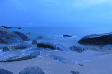 view of the beach, stone and sea at night