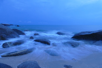 view of the beach, stone and sea at night