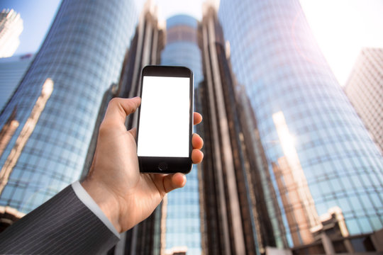 Hand Holding Mobile Cell Phone Cellphone Against City Buildings Business Background Businessman Blank White Screen Card