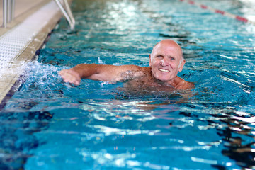 Healthy senior man swimming in the pool. Happy pensioner enjoying sportive lifestyle. Active...