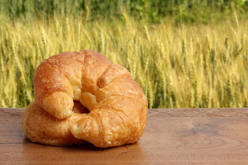 croissant bakery on teakwood table lighting and barley field