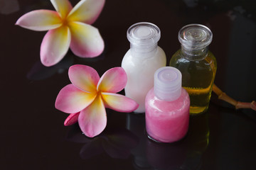 mini set of body bath care on black background decorated with pink flower