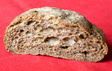 Half of fresh baked bread on a red linen tablecloth