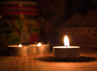 Three candles on a table in a dark