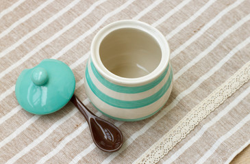 Green pastel porcelain jar and brown spoon with cute fabric.