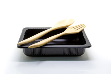 Black Plastic food container with wood spoon and fork on white background