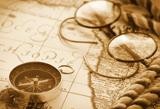 Compass and glasses on vintage map
