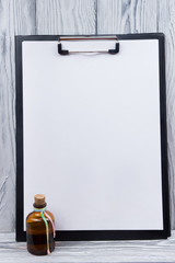 Clipboard with blank sheet of paper on wood background. Copy space