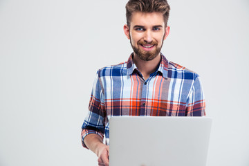 Smiling casual man using laptop