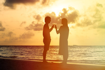 Silhouette of couple drinking wine at sunset beach