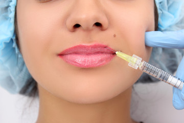 Beautiful woman gets an injection in her lips.