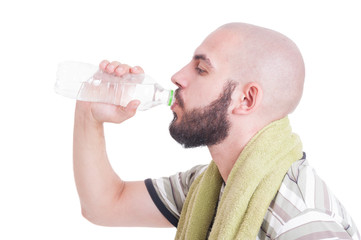 Thirsty man drinking cold water with towel arround his neck