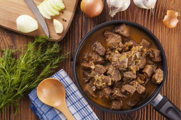 Beef stew - wooden background
