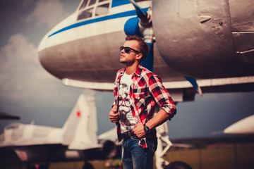 man standing near the aircraft jeans and shirt