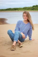 Girl resting on the beach, on the banks of the river
