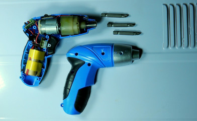 Electric screwdriver cutaway and set of nozzles on white background
