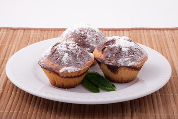 Three tasty muffins on a white plate