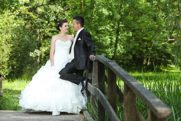 Wedding photo on wooden bridge in nature