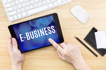 Finger click screen with E-business word with keyboard and noteb