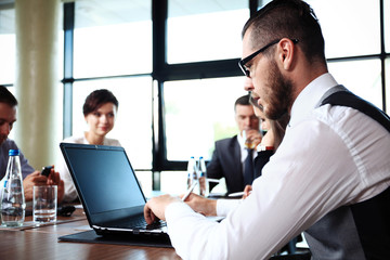 Handsome businessman working with laptop in office