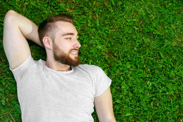 Young man lying on the grass in park