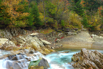 rapids on a rocky mountain river in autumn