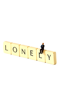 Miniature senior man lonely.
Miniature scale model senior man on tiles spelling the word lonely.