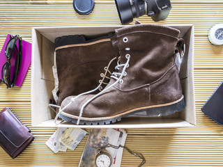 Open box with a pair of boots. Preparing an adventure trip.