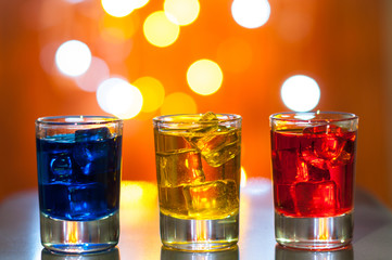 Three glasses with berry liqueur on the bar at a nightclub