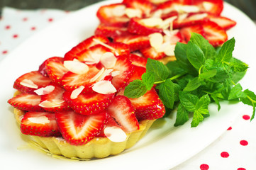 strawberry cake with fresh mint leaves on the wooden surface. Selective focus