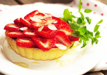 strawberry cake with fresh mint leaves on the wooden surface. Selective focus