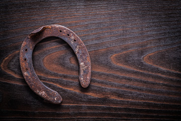 Rusted obsolete horsehoe on vintage dark wood board copy space i