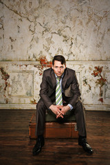 Businessman sitting on suitcases. Business journey.