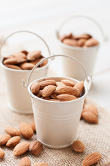 Raw almonds on white wooden board