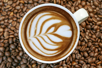 Coffee bean background with cup of fresh hot espresso coffee art
