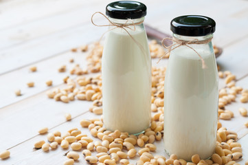 Soy milk [Soya milk ] in  glass bottle with soy pods on white wo