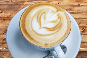 Cup of freshly made espresso in coffee shop on light brown wood