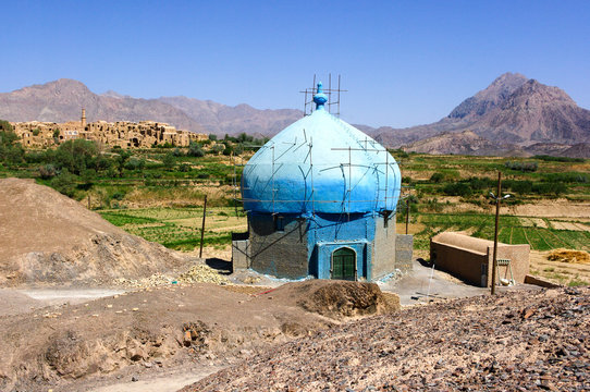 Mosquée de campagne bleu devant un très vieux village, un oasis et des montagnes