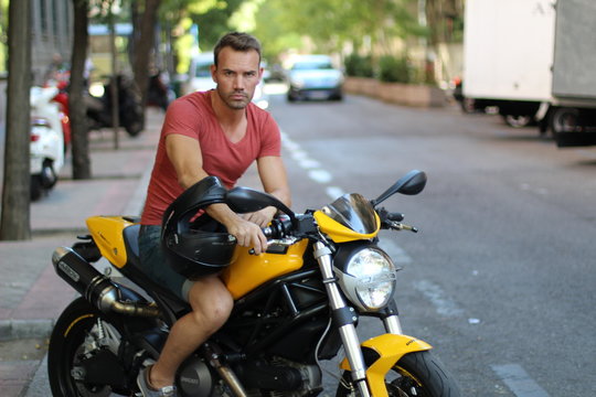 Hot middle aged man motorcyclist in the city