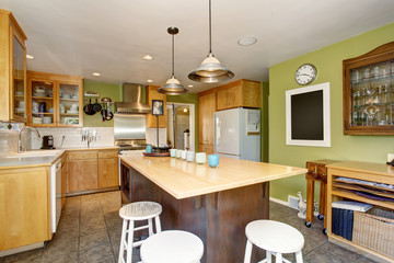Unique kitchen with green walls, and island.