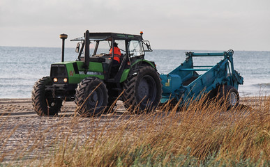 Obraz premium Tractor cleaning the beach
